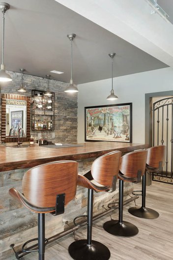 Basement with wooden bar top and high top chairs