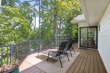 Chestnut Trex Select deck with lounge chairs and black rail overlooking trees and a lake