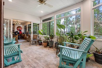 Greenhouse room with brick floors, rocking chairs and plants