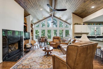 Den sunroom area with vaulted ceiling, wood floors and black tiled fireplace
