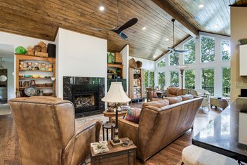 Den sunroom area with vaulted ceiling, wood floors and black tiled fireplace