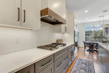 Simple modern kitchen remodel with blue and white cabinets, white quartz countertops, and a custom hood