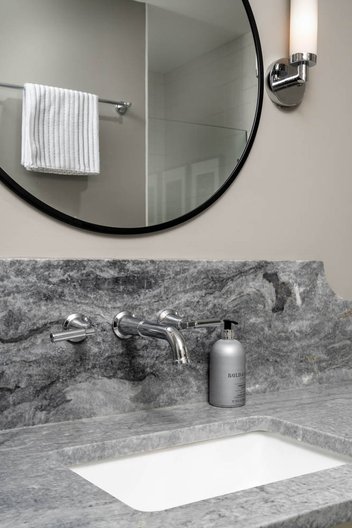 Bathroom sink with gray countertop and mounted foucet