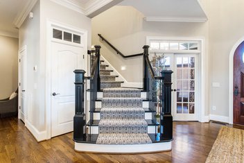Refinished black staircase with custom carpet stair runner