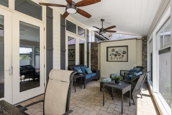 Inside of screened porch with patio furniture and glass windows and doors