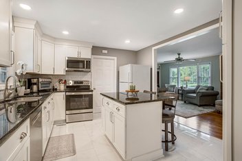 Small white kitchen with island in family home