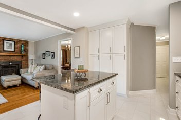 Small white kitchen with island in family home