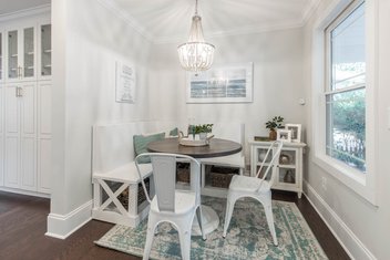 White breakfast nook with bench seating on one side and chairs on the other