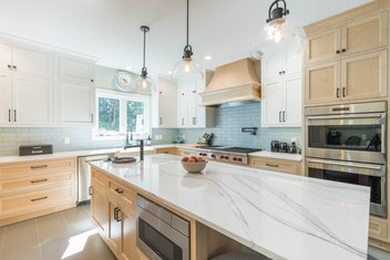Modern kitchen with white oak cabinets, white granite countertops and blue subway tile backsplash