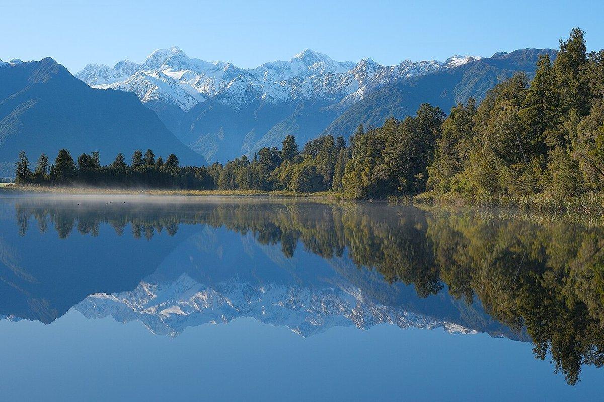 Aoraki/Mount Cook and Mount Tasman reflected in the still dawn water of Lake Matheson, Westland Tai Poutini National Park, New Zealand