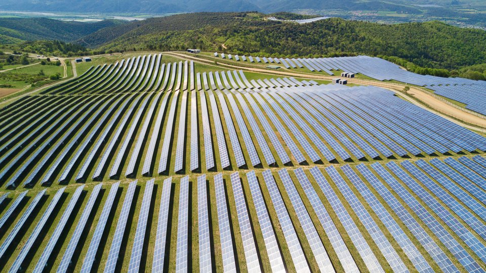 Aerial view of very large solar field in a green landscape