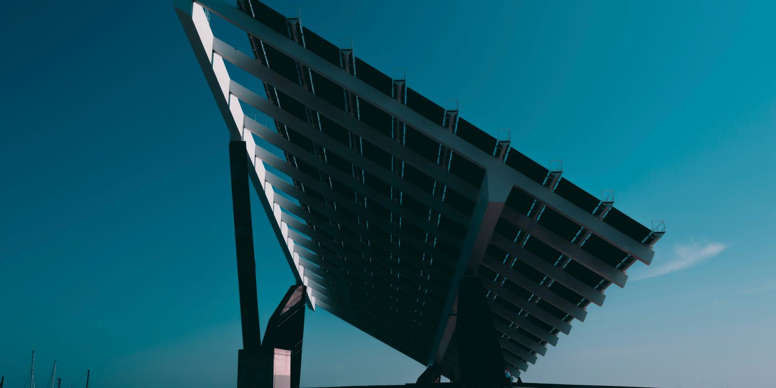 Large outdoor solar panel installation dwarfing two tiny figures