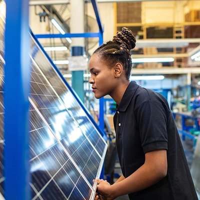 Quality engineer examining solar panels in factory