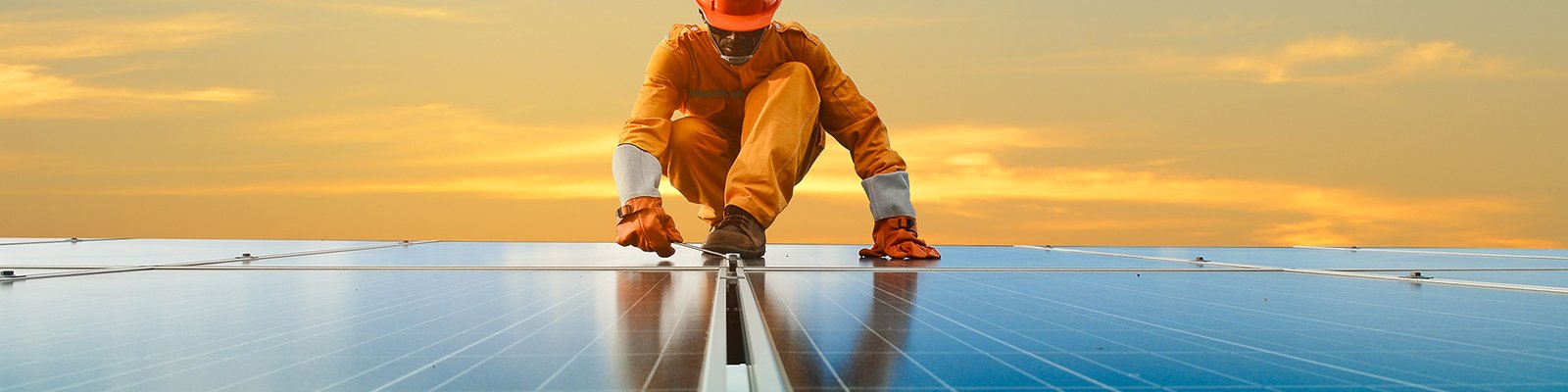 Worker in safety gear inspecting panels