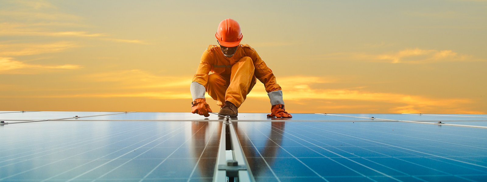 Worker in safety gear inspecting panels