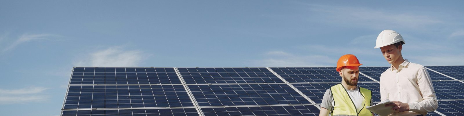 Worker reviewing papers near solar panels