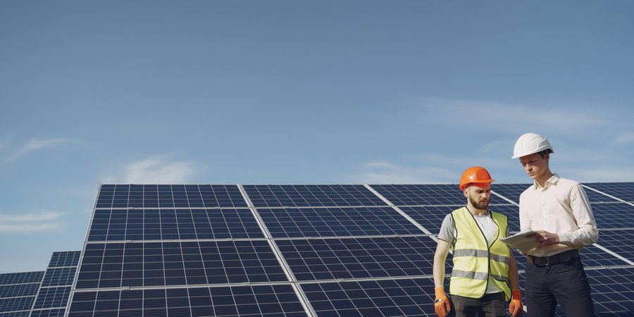 Worker reviewing papers near solar panels