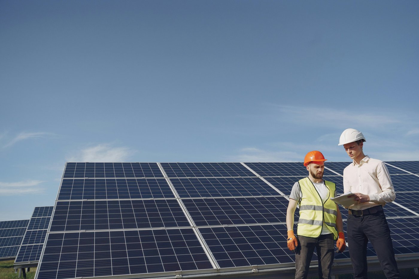Worker reviewing papers near solar panels