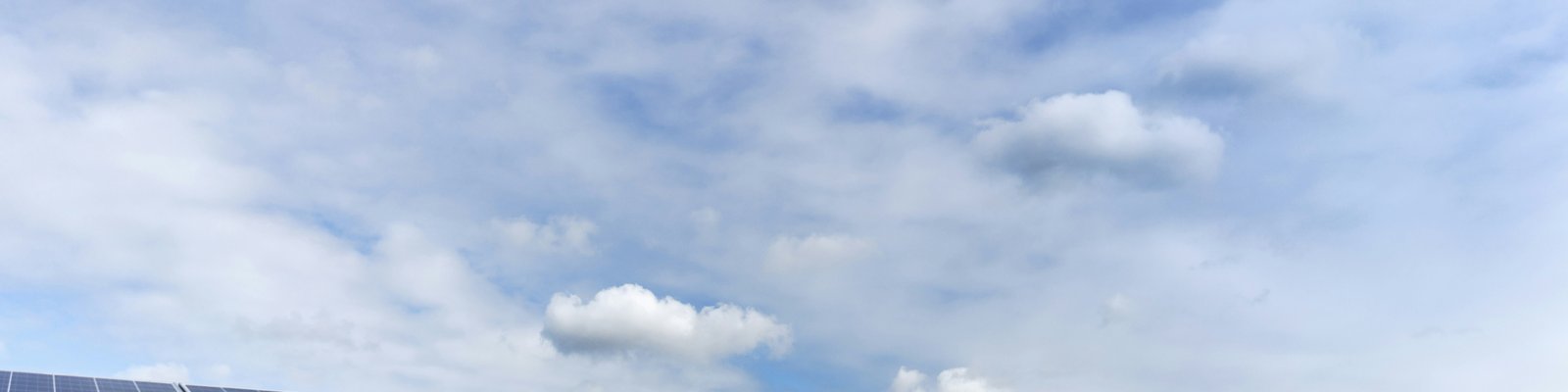 white and black solar panels under white clouds and blue sky during daytime