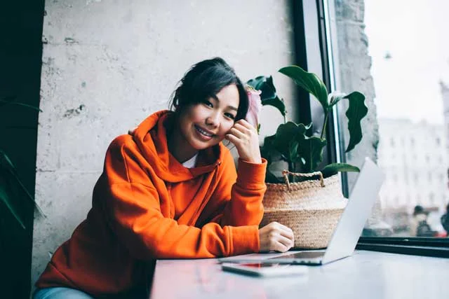 smiling-asian-female-freelancer-with-laptop-2023-08-01-19-20-27-utc