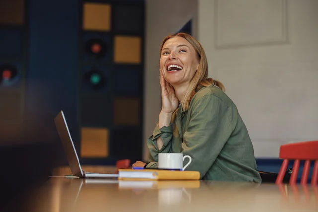 smiling-businesswoman-working-on-laptop-in-modern-2023-08-22-02-39-36-utc