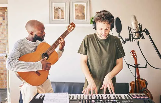 two-musicians-recording-guitar-and-keyboard-and-voice-with-microphone