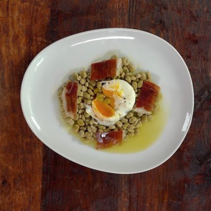 Tender baby green beans with poached egg and Jamón Ibérico de Bellota Spanish dish