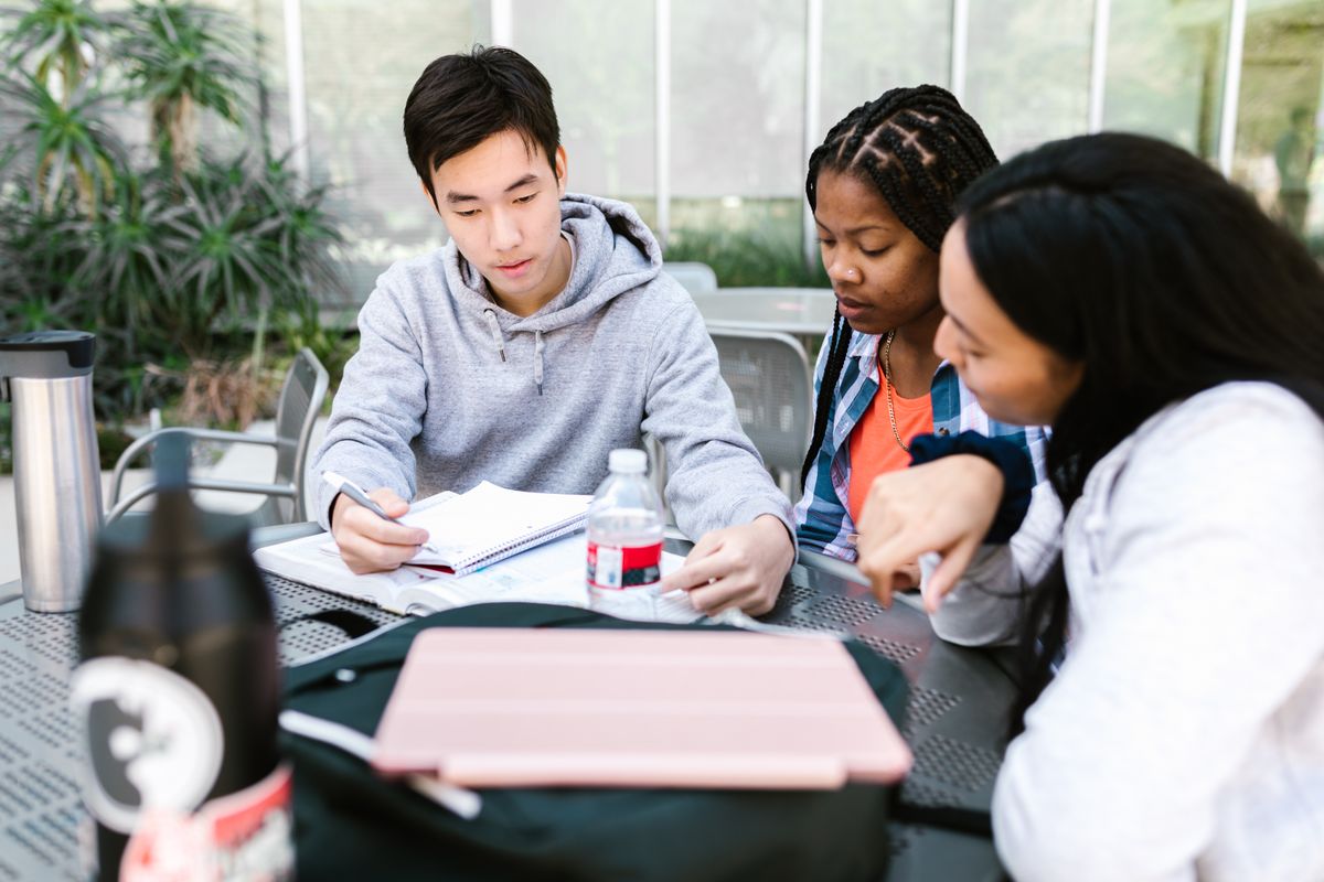 Três estudantes conversando durante uma sessão de estudo
