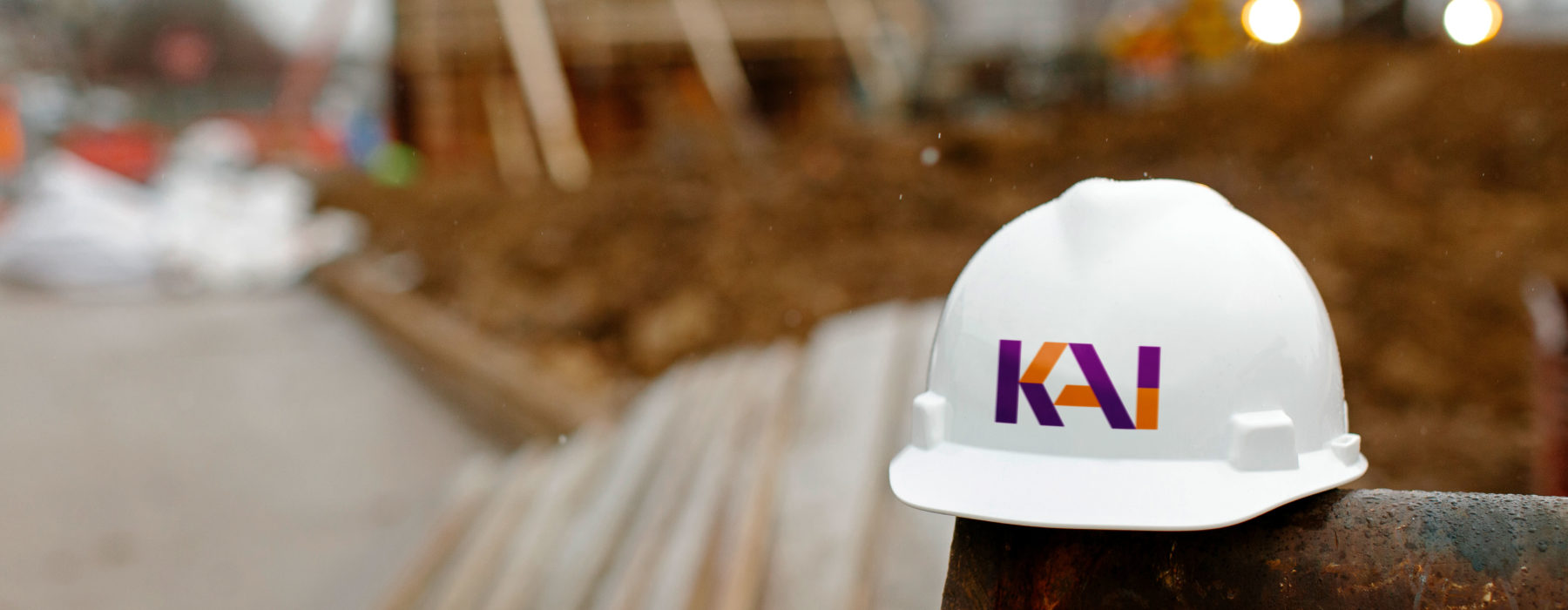 KAI Enterprises Construction Hat in front of a Construction Site