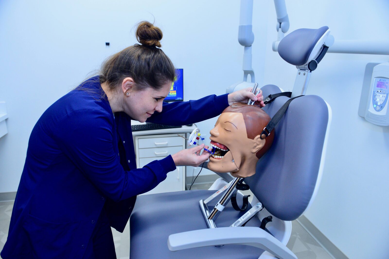 Student practicing dental services on a dummy in a STLCC new teaching lab