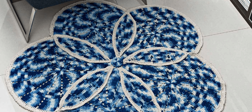 Almofada de crochê e tapete azul e cru