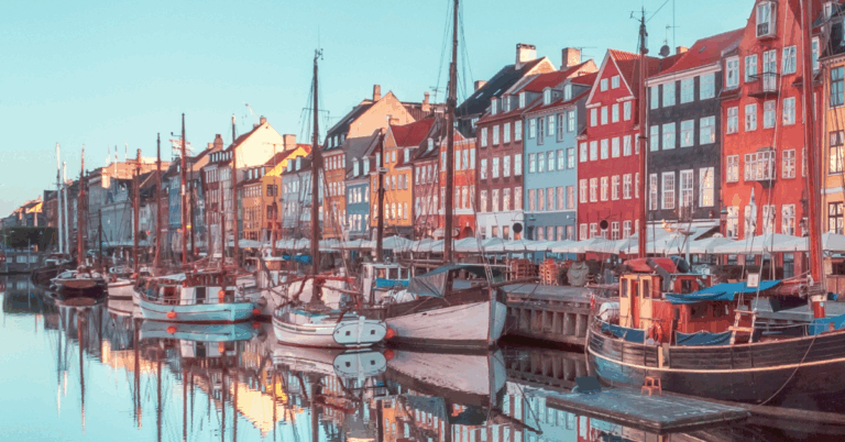 Vista do canal de Nyhavn, em Copenhague, Dinamarca, com barcos ancorados e uma fileira de prédios históricos