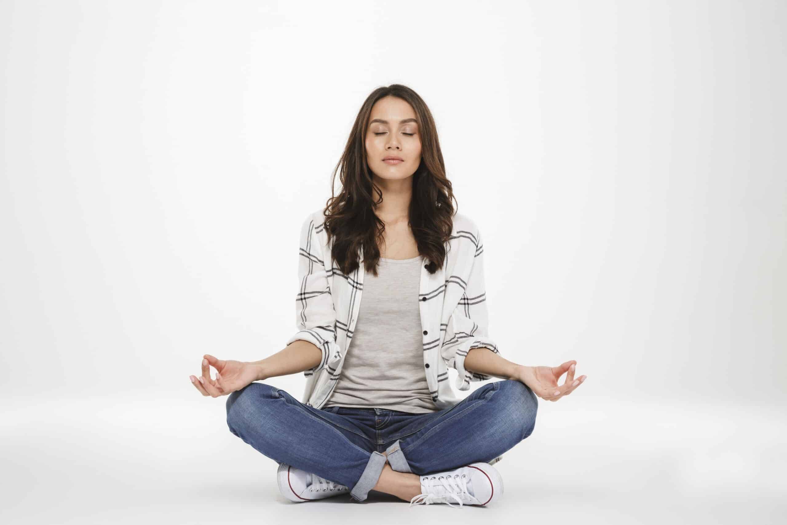Mulher meditando em posição de lótus, simbolizando atenção plena, autoconhecimento e clareza emocional. — Foto: Freepik