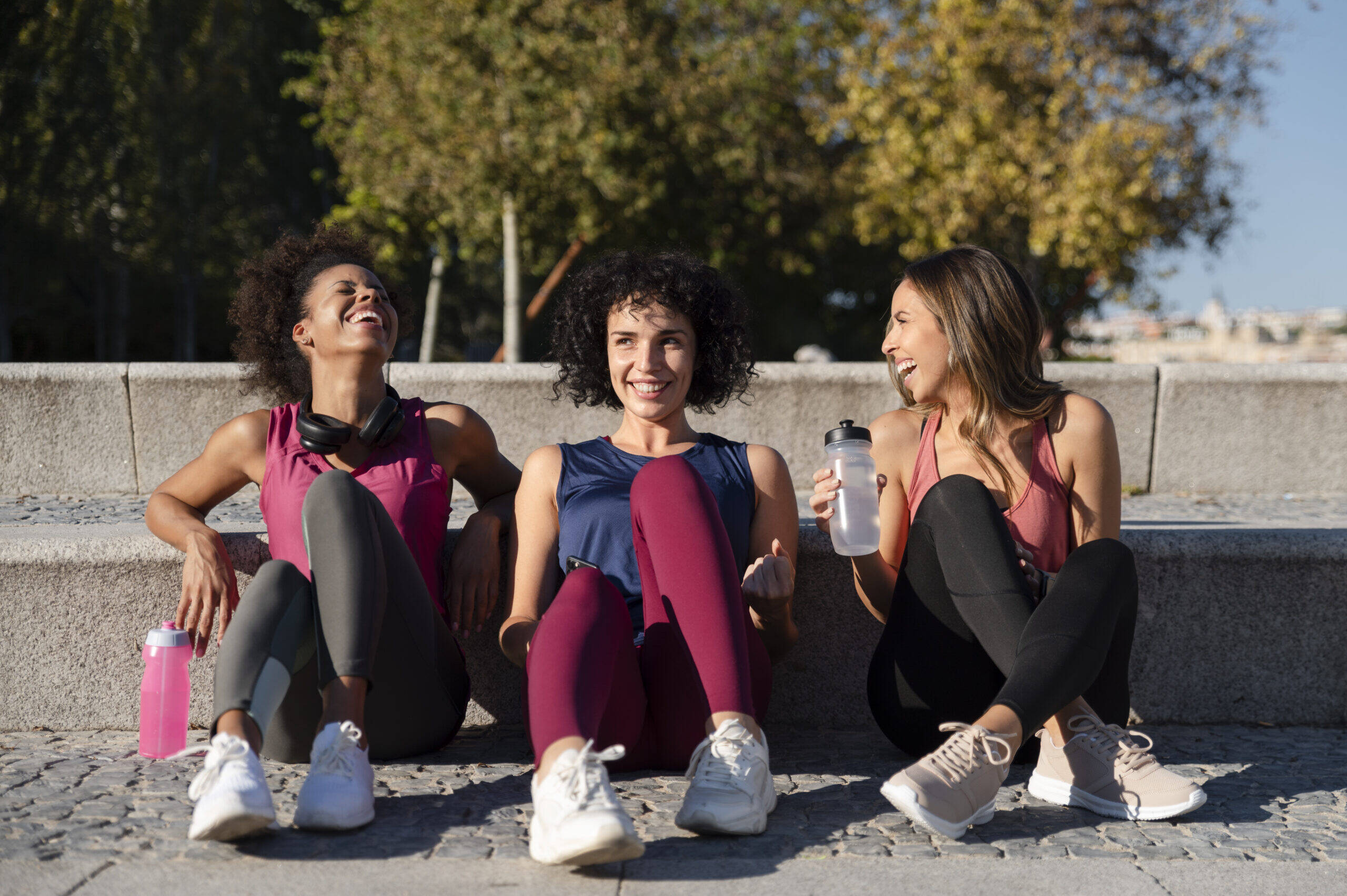 Três mulheres sorrindo após o treino, representando a ação da ocitocina e a Neurociência da Confiança — quando o cérebro fortalece vínculos e a autoconfiança
