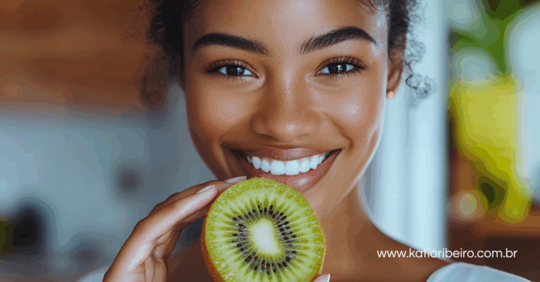 Mulher com um kiwi na mão, uma das frutas ricas de vitamina C que auxilia a produção de colágeno para a pele