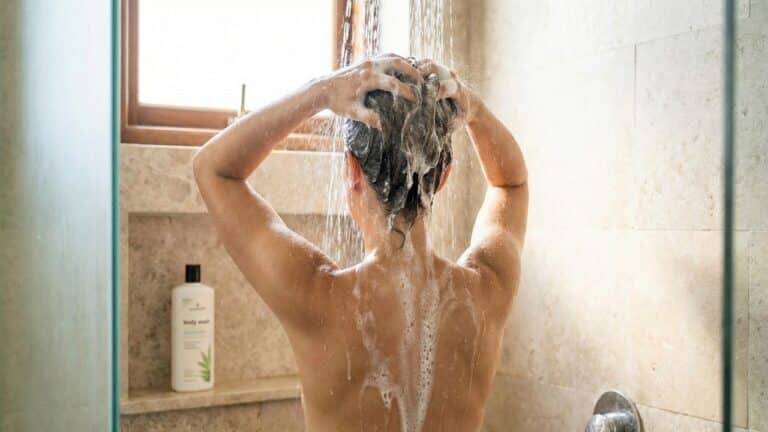 Mulher lavando cabelo no banho