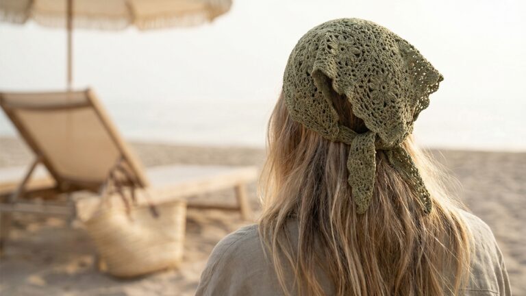 Vista de costas de mulher usando bandana de croche artesanal em verde com trama delicada em ambiente praiano com luz natural