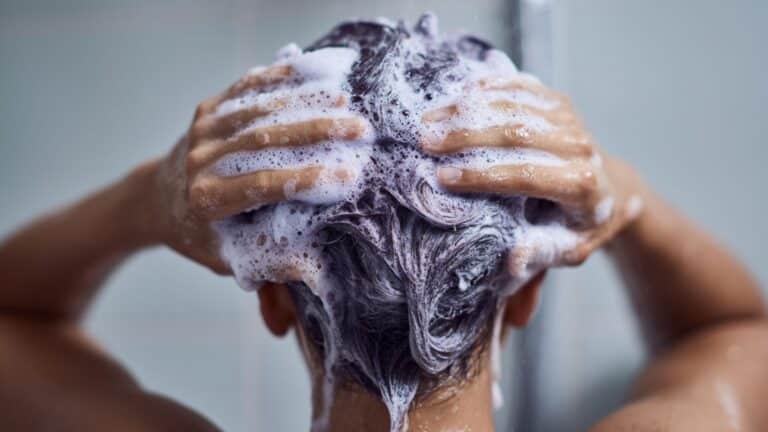 Mulher lavando cabelo com shampoo roxo