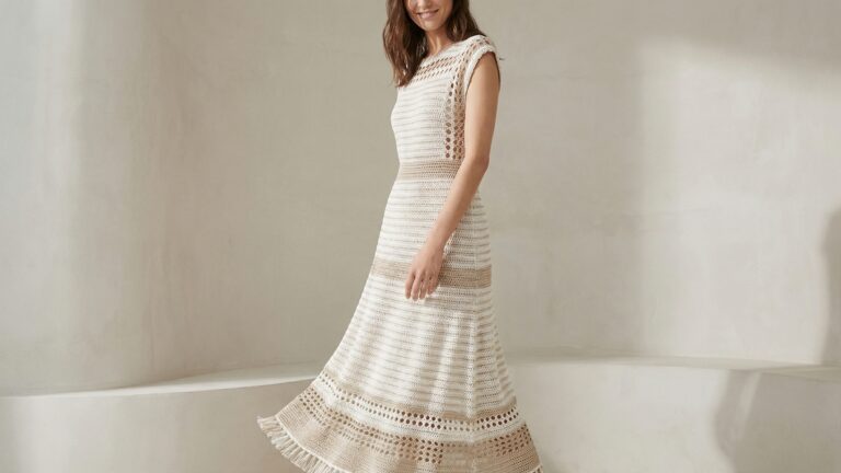 Mulher usando vestido de croche em tons claros com lurex, modelagem elegante e estetica fashion verao