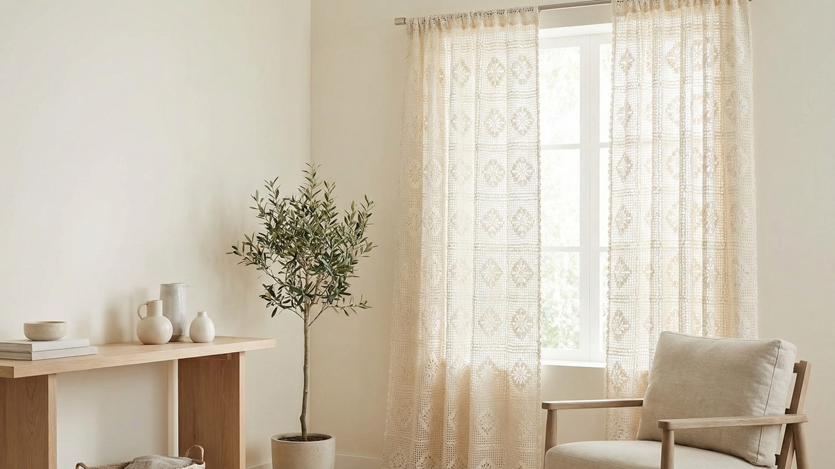 Sala iluminada com cortinas de croche off white artesanal em janela ampla com moveis de madeira plantas e decoracao minimalista