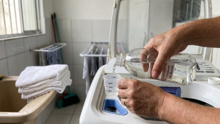 Pessoa dosando vinagre para acompanhar a lavagem de toalhas de banho