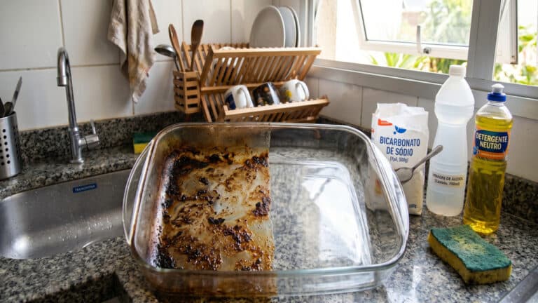 Refratário de vidro com a metade suja e outra metade limpa graças ao ingredientes da mistura mágica contra gordura