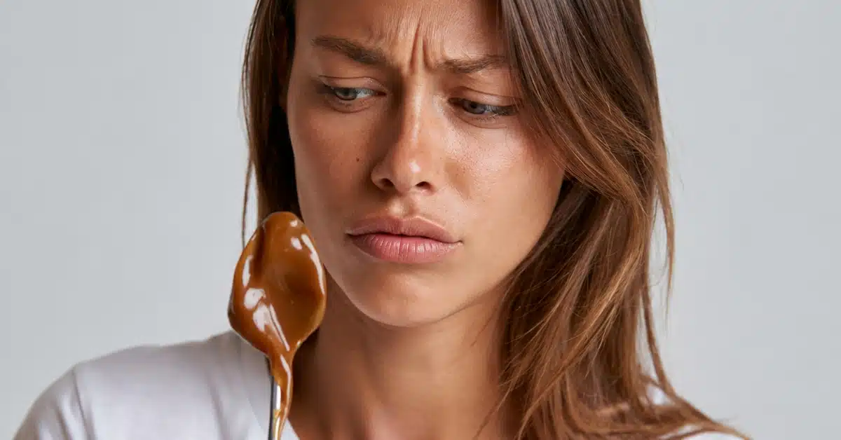 Mulher observando um alimento com expressão de dúvida, representando a diferença entre nutricionismo e uma visão mais ampla da nutrição.