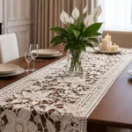 Caminho de mesa de crochê branco com flores sobre mesa de jantar
