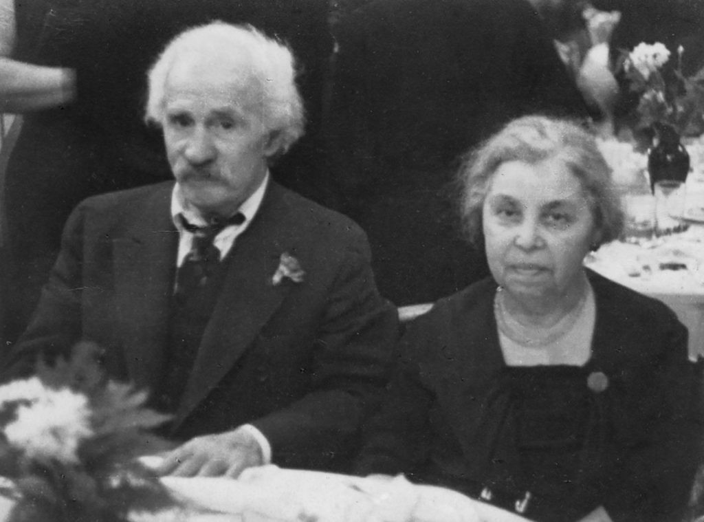 elderly couple sit at table