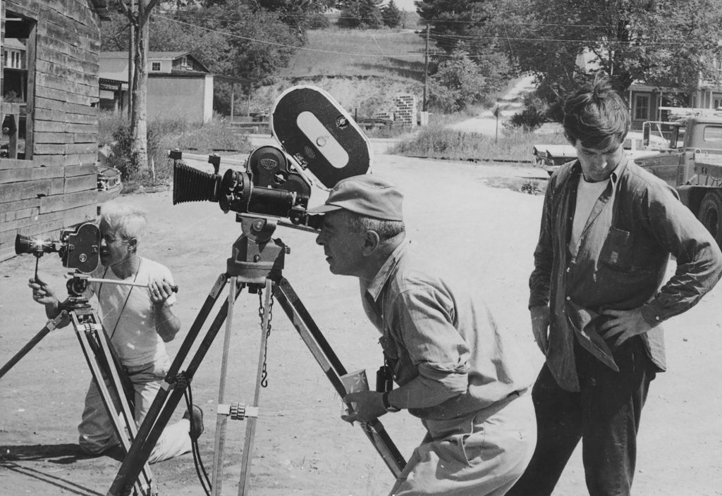 Two men at cameras, a third looks away