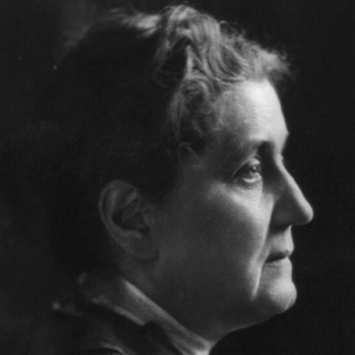 A grayscale photo portrait of Jane Addams looking directly to the right into the distance. Her hair is braided up onto her head in a practical style. Her facial expression looks exhausted and a little worried. Photo Credit: Moffett,  1914. Source: Library of Congress