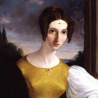 An oil painting portrait of Harriet Mill. She is wearing a dress with puffy sleeves and a round collar. Her hair in a neat bun with a large coil of curls on either side of her head. She has rosy cheeks and she has a blank facial expression. Source: https://www.npg.org.uk/collections/search/portrait.php?search=ap&npgno=5489&eDate=&lDate=
