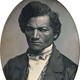 A sepia-toned photo portrait of Frederick Douglass. He is wearing a classic suit with a fun-patterned undershirt and a bow-tie. His hair is an afro styled into a side part. He is looking firectly into the camera with an intense and stern facial expression. Photographer: Samuel J. Miller. Year: 1850. Source: Art Institute of Chicago