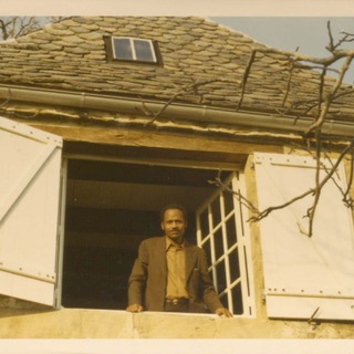 James A. Emanuel at Michel Fabre's home in the early 1970s. Emanuel is looking out of a second story window. He is dressed in a brown leisure suit. 